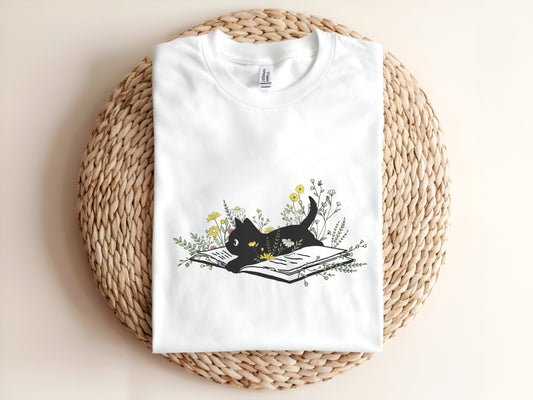 Adult graphic t-shirt featuring black cat sitting on books, unisex tee for cat lovers.