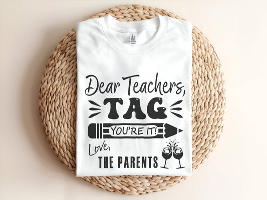 Adult graphic t-shirt featuring “Dear Teachers Tag You’re It” slogan, humorous unisex tee.